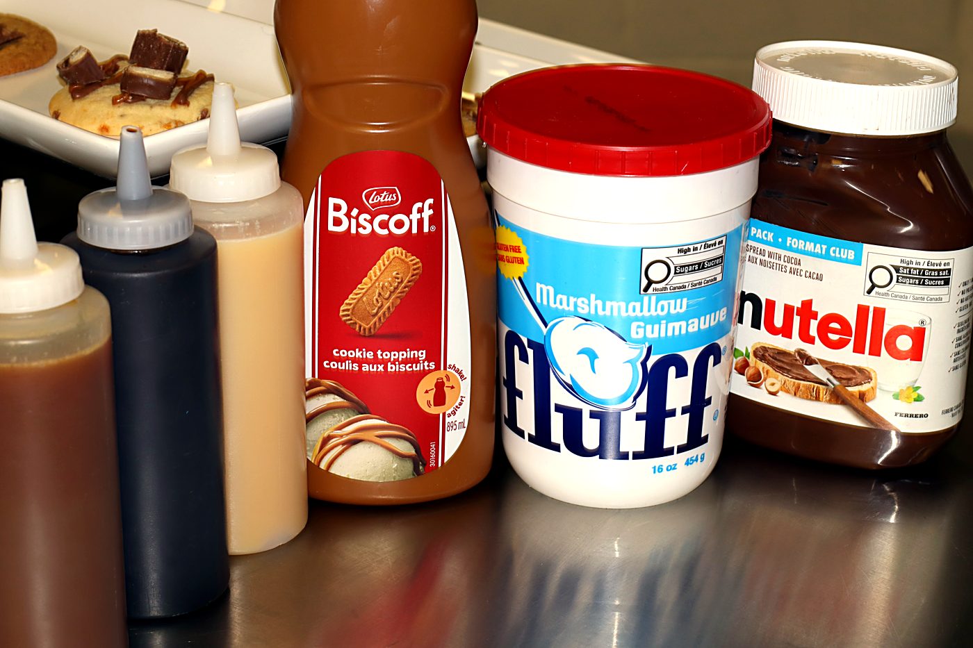 Sweet Lou's sauces, Biscoff, Marshmallow Fluff and house squeeze bottles at the counter